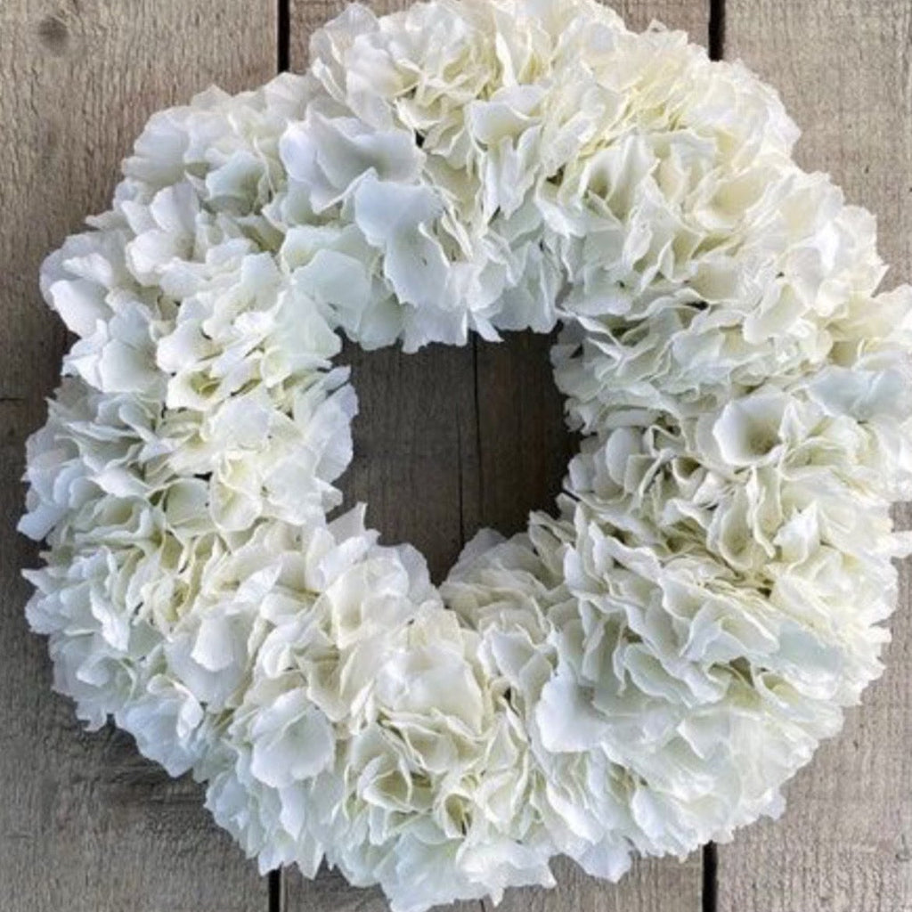 A white faux hydrangea wreath displayed on a rustic wooden plank background, with 'On Etsy now' text overlay at the top.